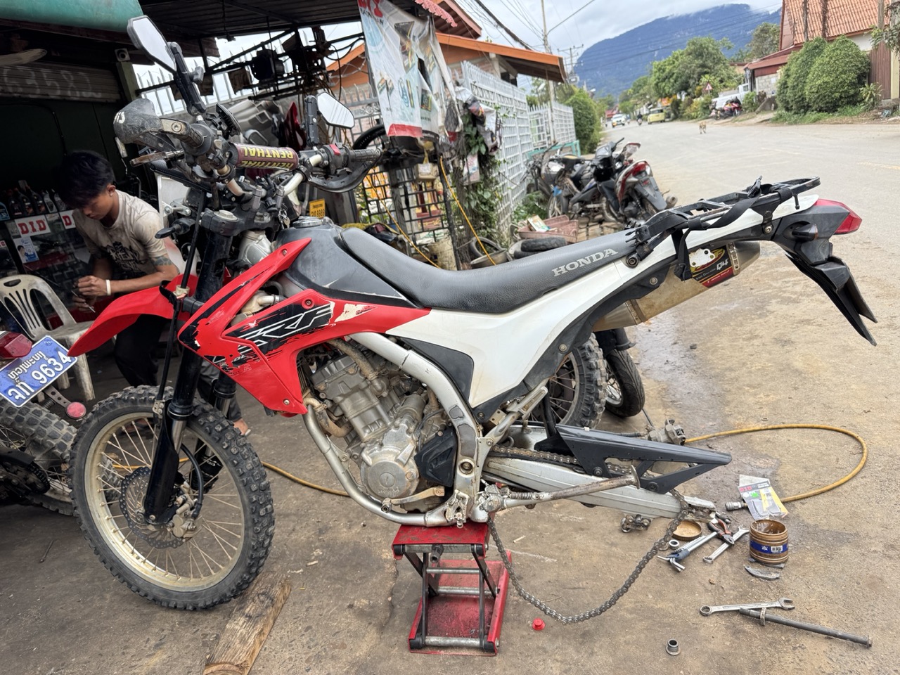 Honda CRF motorcycle being serviced at a small mechanic shop in Luang Prabang